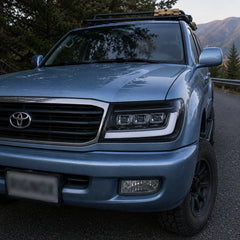 1998-2003 Toyota Land Cruiser 100 LED Triple Projector Headlights Assembly — driving in mountain road — H-LC100-98