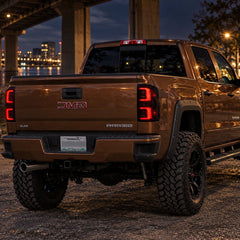 2014-2018 GMC Sierra 1500 & 2015-2019 Sierra 2500HD/3500HD LED Tail Lights Assembly — illuminated smoked tail lights on truck at night — T-SIE14-SR