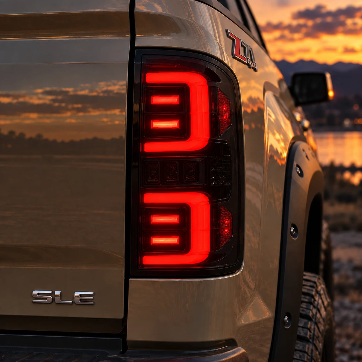 2014-2018 GMC Sierra 1500 & 2015-2019 Sierra 2500HD/3500HD LED Tail Lights Assembly — illuminated smoked tail light close-up at sunset — T-SIE14-SR